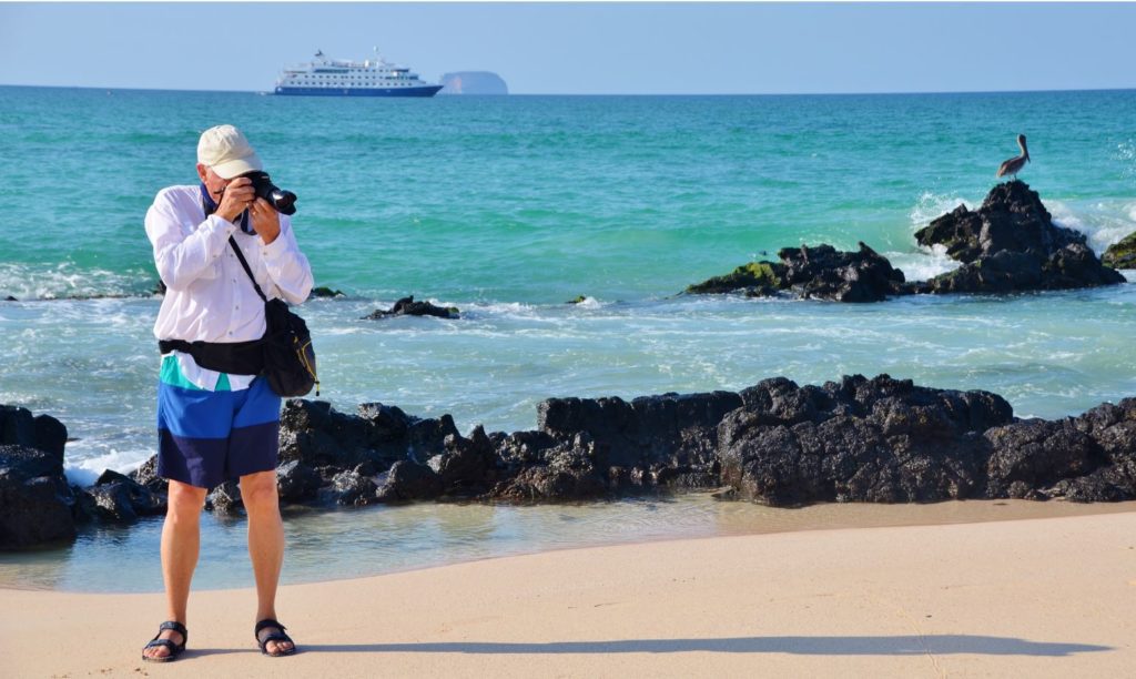 Guest Photographing At The Shore Of The Galapagos Islands.