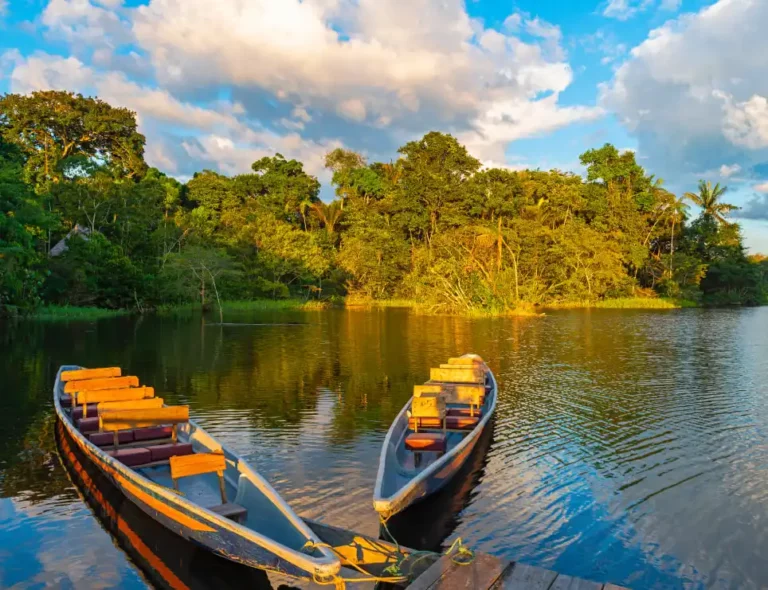 Boats On A Calm River Within The Greater Amazon Basin