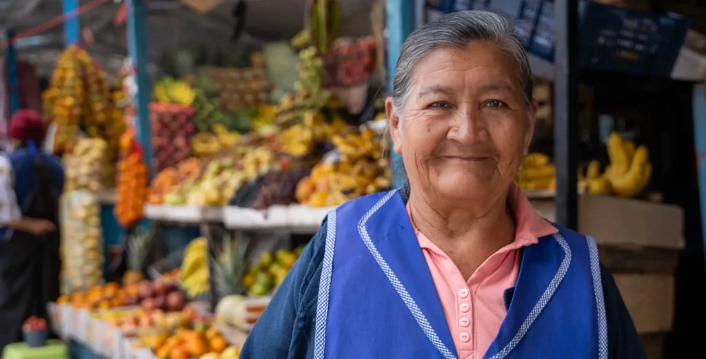Vendor at her fruit stall in the Copacabana vegetable market, Otavalo
