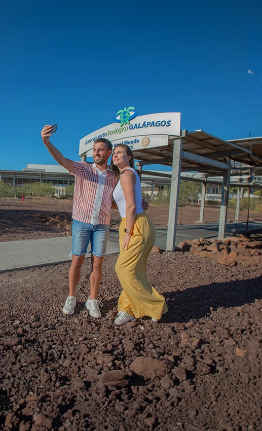 Couple taking a farewell selfie at Seymour Airport in the Galapagos Islands