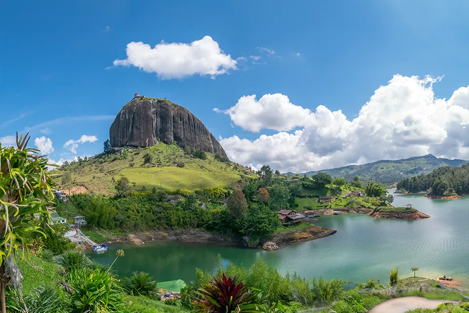Guatape Travel Guide: A Panoramic View Of The Massive Monolithic Rock Of Guatapé Overlooking The Turquoise Reservoir And Lush Green Landscape In Antioquia, Colombia.