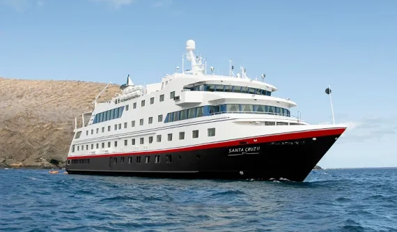 Santa Cruz II, yate de expedición navegando junto a la costa de una isla de Galápagos