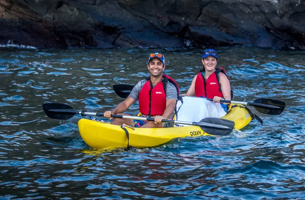 Guests kayaking past volcanic cliffs during a Yacht Isabela II Galapagos expedition