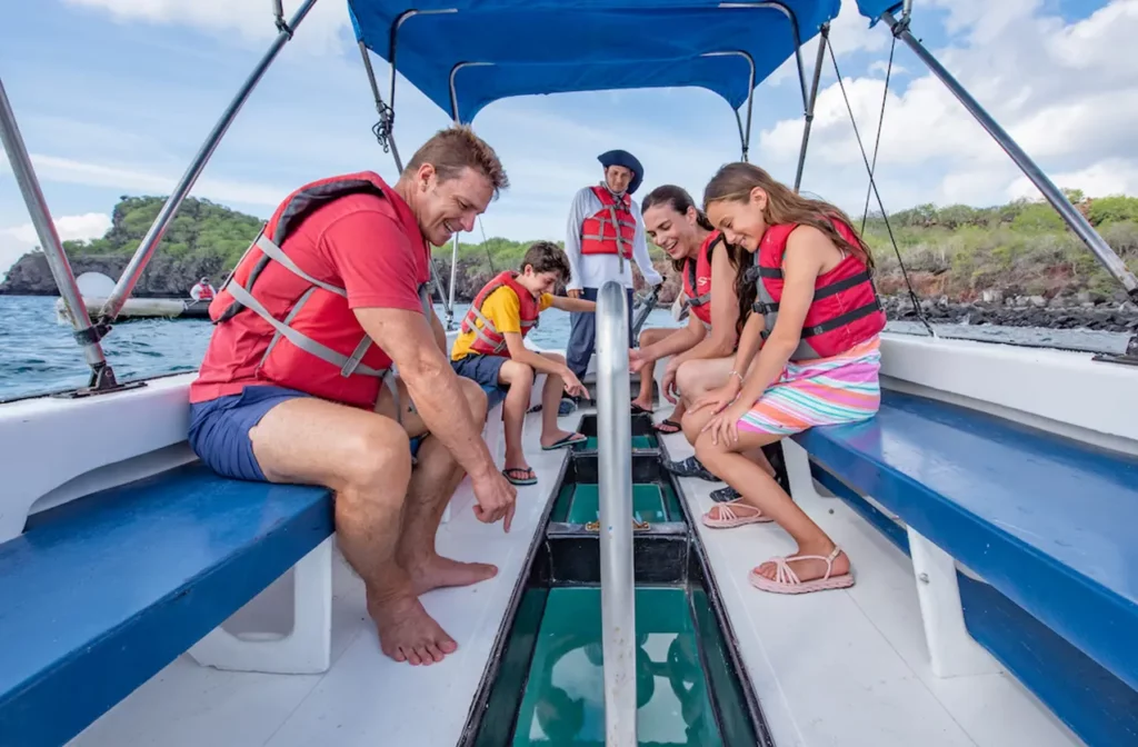 Guests aboard the glass-bottom boat viewing marine life, Yacht Isabela II Galapagos cruise