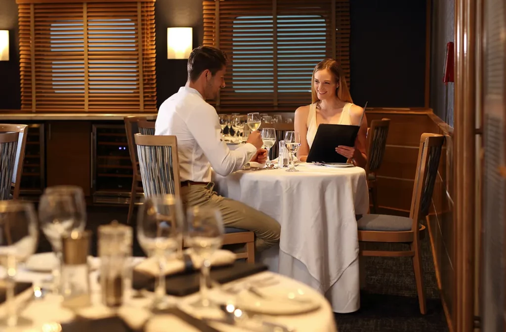 Couple dining in the onboard restaurant of Yacht Isabela II, Galapagos cruise