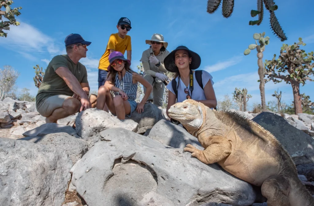Galapagos luxury cruise guests observe land iguana on Santa Fe Island aboard Yacht La Pinta