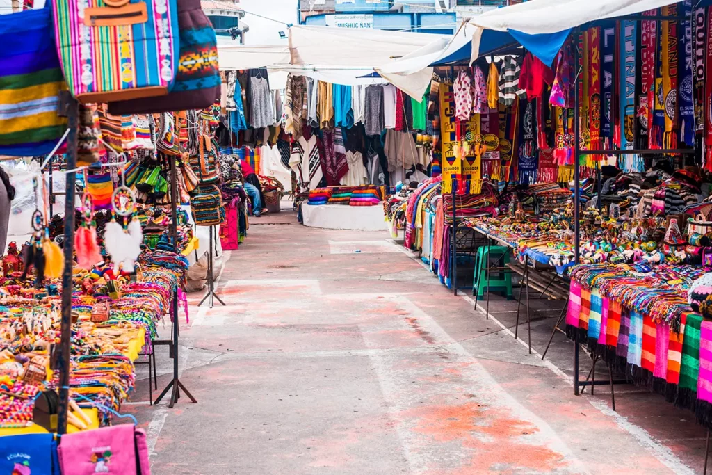 Aisle of hanging ponchos and blankets at Otavalo's Plaza de los Ponchos