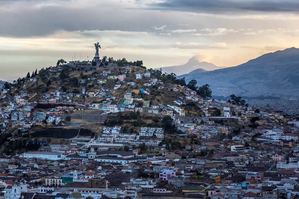 Panoramic view of Quito from San Juan viewpoint, with a volcano in the distance