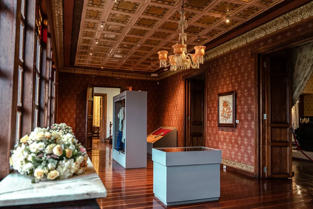 Ornate red damask room with chandelier at the Remigio Crespo Museum