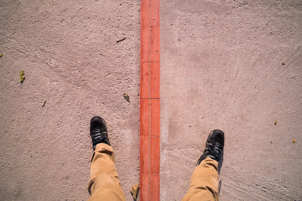 Standing with one foot on each side of the equator line at Mitad del Mundo